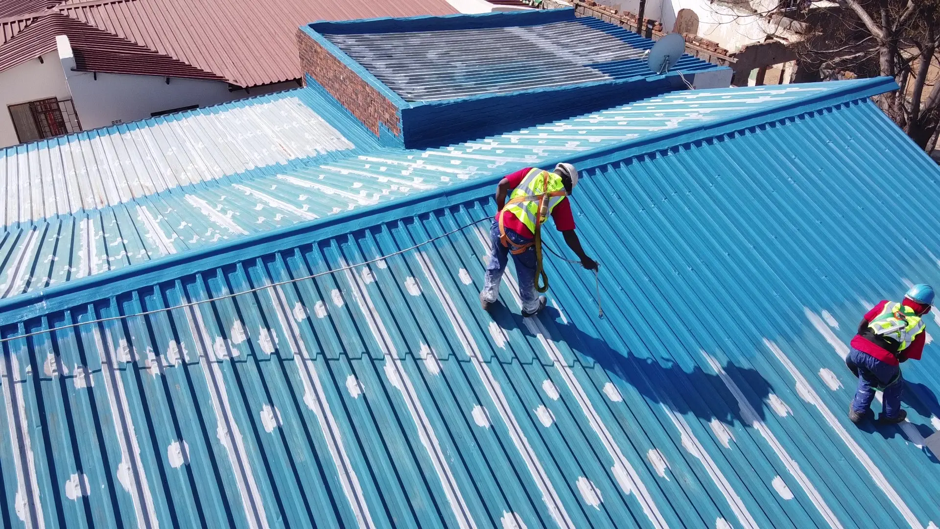 Protective roof coating being applied to an industrial building